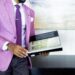 Man in Pink Suit Jacket Holding Book